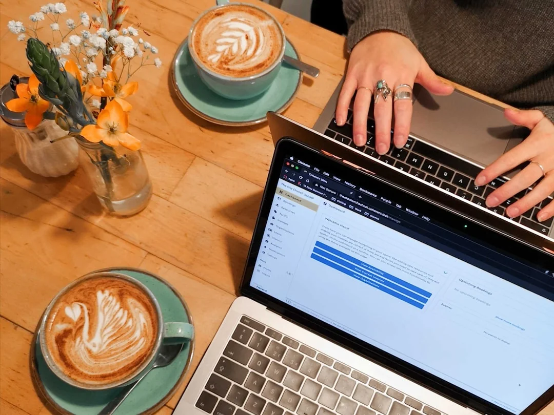 A modern workspace showing hands analyzing marketing data on a laptop and paper documents.